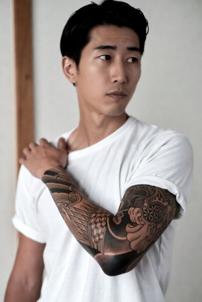 20+ Japanese Tattoos for Men: Discover the Bold and Intricate Designs 2026 5 A close-up shot of a Japanese man in a t-shirt, highlighting his intricate arm tattoo.