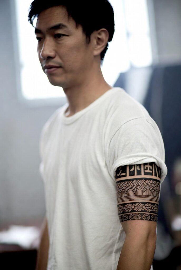 20+ Japanese Tattoos for Men: Discover the Bold and Intricate Designs 2026 7 A stylized photo of a Japanese man in a t-shirt, clearly emphasizing the tattoo on his arm.