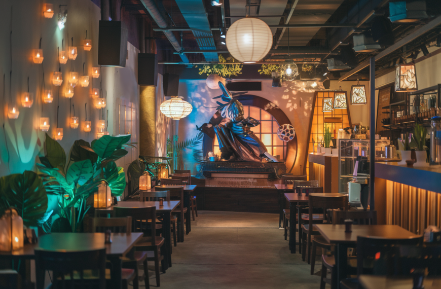 A cinematic photo of a warm atmospheric lighting Jujutsu-inspired Japanese café scene. The café has a traditional wooden interior mixed with modern anime-style décor. There are subtle glowing talismans, floating paper charms, and mystical energy effects surrounding the café counter. A stylish Japanese barista is preparing a colorful, fantasy-themed dessert and drink. The background contains a few patrons. The photo has a highly detailed texture and a cozy yet magical ambiance.