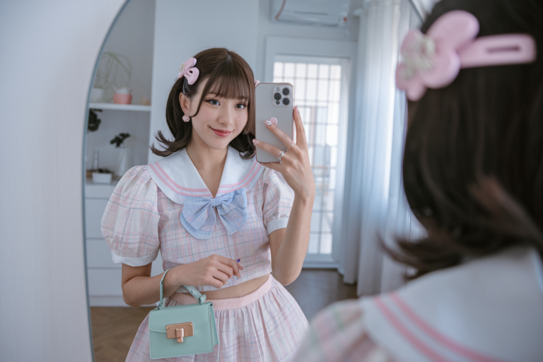 Japanese Women Kawaii Fashion: 5 Cute and Playful Styles 2026! 6 Japanese woman taking a mirror selfie wearing a pastel kawaii outfit with cute hair clips and a small pastel handbag, bright soft interior — japanese women kawaii fashion.