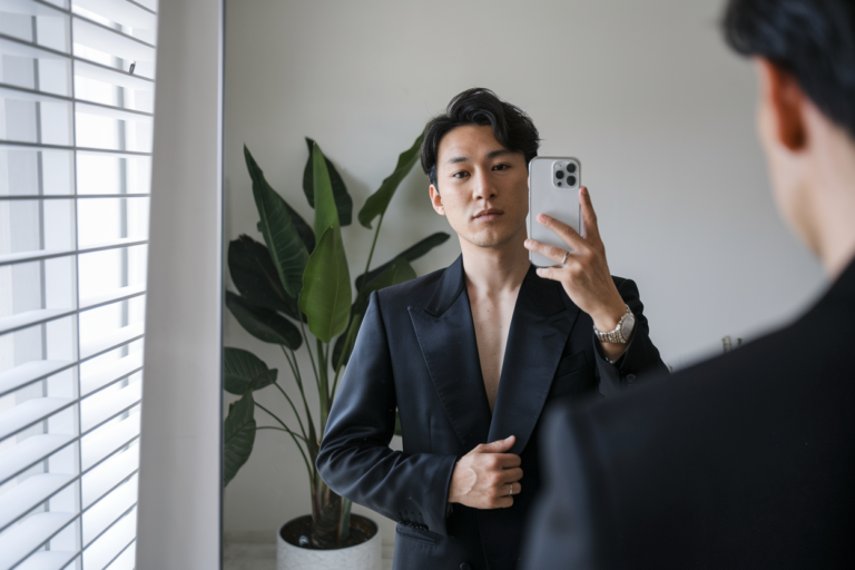 Japanese Mens Minimalist Style: 5 Clean and Modern Looks 2026! 7 Japanese man taking a mirror selfie wearing an all-black minimalist outfit with clean, sharp lines, soft natural lighting — japanese mens minimalist style.