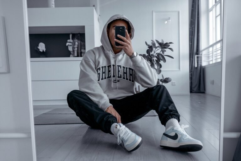 Japanese Mens Streetwear: 5 Modern Casual Looks 2026! 9 Japanese man taking a mirror selfie wearing an oversized hoodie paired with stylish sneakers, clean minimal interior — japanese mens streetwear.