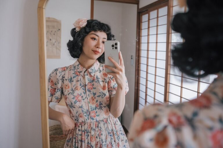 Japanese Women Vintage Fashion: 5 Soft and Retro-Inspired Looks 2026! 10 Japanese woman taking a mirror selfie wearing a floral retro vintage dress made of soft fabric, gentle natural lighting — japanese women vintage fashion.