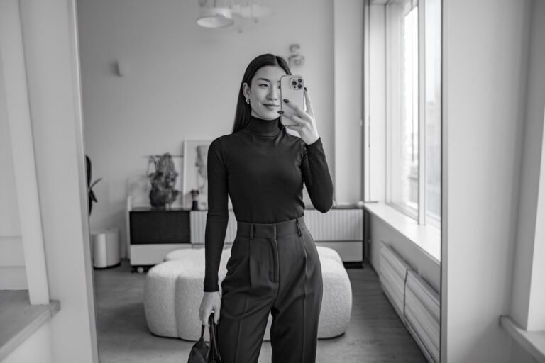 Japanese woman taking a mirror selfie wearing an executive minimalist turtleneck office outfit with refined styling, calm professional setting — women business turtleneck outfits.