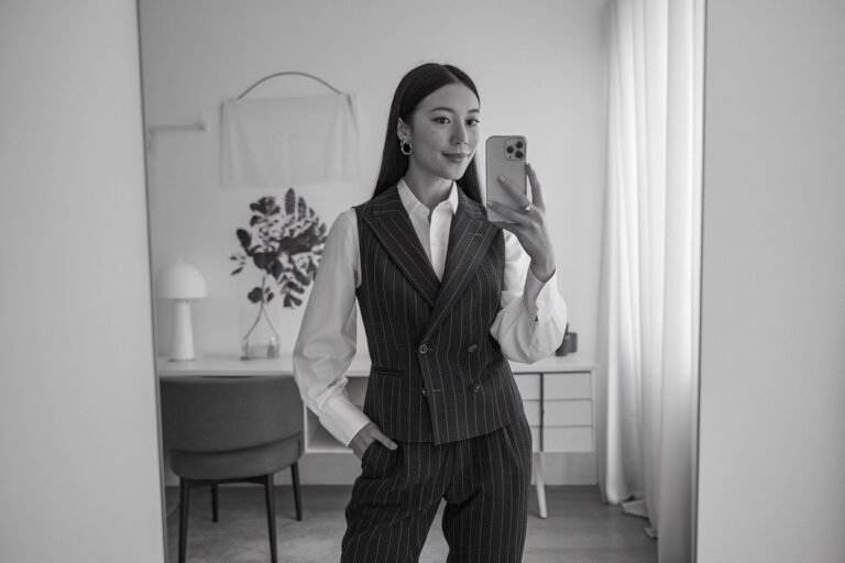 Japanese woman taking a mirror selfie wearing an executive business vest power outfit with refined tailoring, calm professional setting — women business vest outfits.